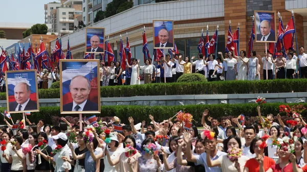 Люди приветствуют кортеж президента РФ Владимира Путина на улице в Пхеньяне Люди приветствуют кортеж президента РФ Владимира Путина на улице в Пхеньяне