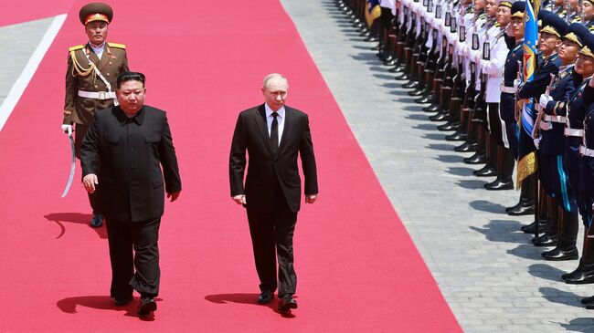 Президент России Владимир Путин и председатель государственных дел КНДР Ким Чен Ын во время церемонии официальной встречи в Пхеньяне