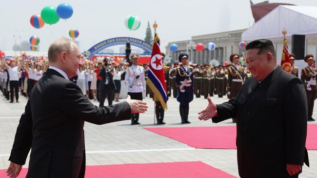 Президент РФ Владимир Путин и председатель государственных дел КНДР Ким Чен Ын во время церемонии официальной встречи на площади Ким Ир Сена в Пхеньяне