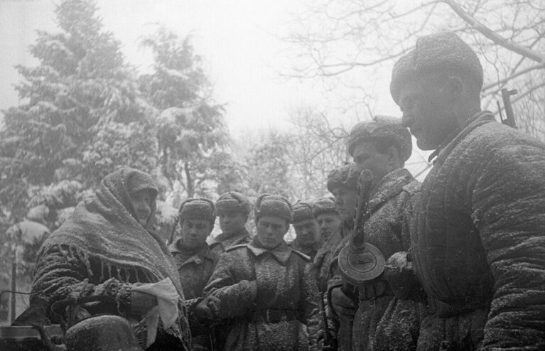 Калининский фронт, Великолукская операция. Оставшаяся в живых жительница села встречает советских солдат-освободителей. Великие Луки, Калининская (ныне Псковская) область, РСФСР, 1943 год.