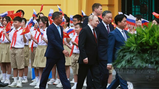 Президент России Владимир Путин и президент Социалистической Республики  Вьетнам То Лам на церемонии официальной встречи на площади у Президентского дворца в Ханое