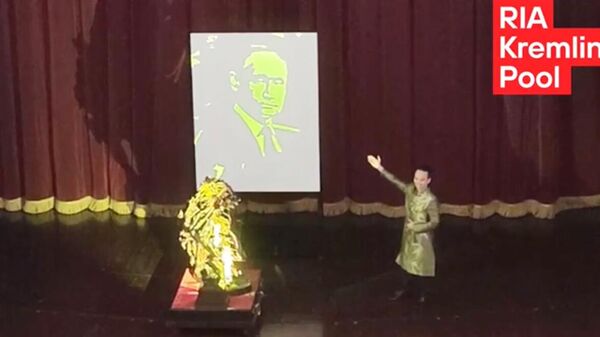 Портрет президента России Владимира Путина, образованный тенью от вращения скульптур берез и коня, на концерте на сцене Большого оперного театра в Ханое