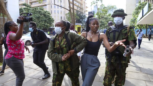 Сотрудники полиции задерживают участницу акции протеста в Найроби, Кения