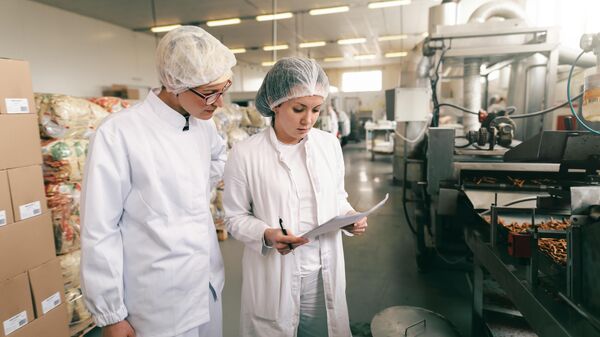 Сотрудники завода проверяют качество продовольственной продукции
