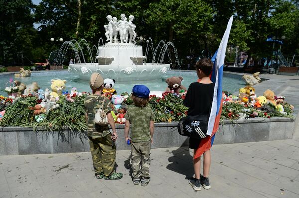 Дети возле стихийного мемориала в Комсомольском парке имени Марии Байды в Севастополе в день траура по погибшим в результате ракетной атаки ВСУ