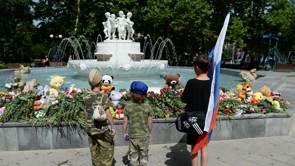 Дети возле стихийного мемориала в Комсомольском парке имени Марии Байды в Севастополе в день траура по погибшим в результате ракетной атаки ВСУ