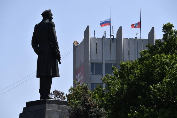 Приспущенные государственные флаги над зданием правительства Севастополя в день траура по погибшим в результате ракетной атаки ВСУ