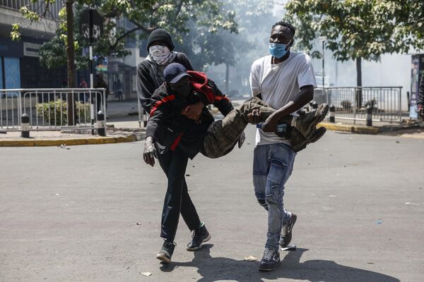Раненого протестующего уносят с центра беспорядков в Найроби