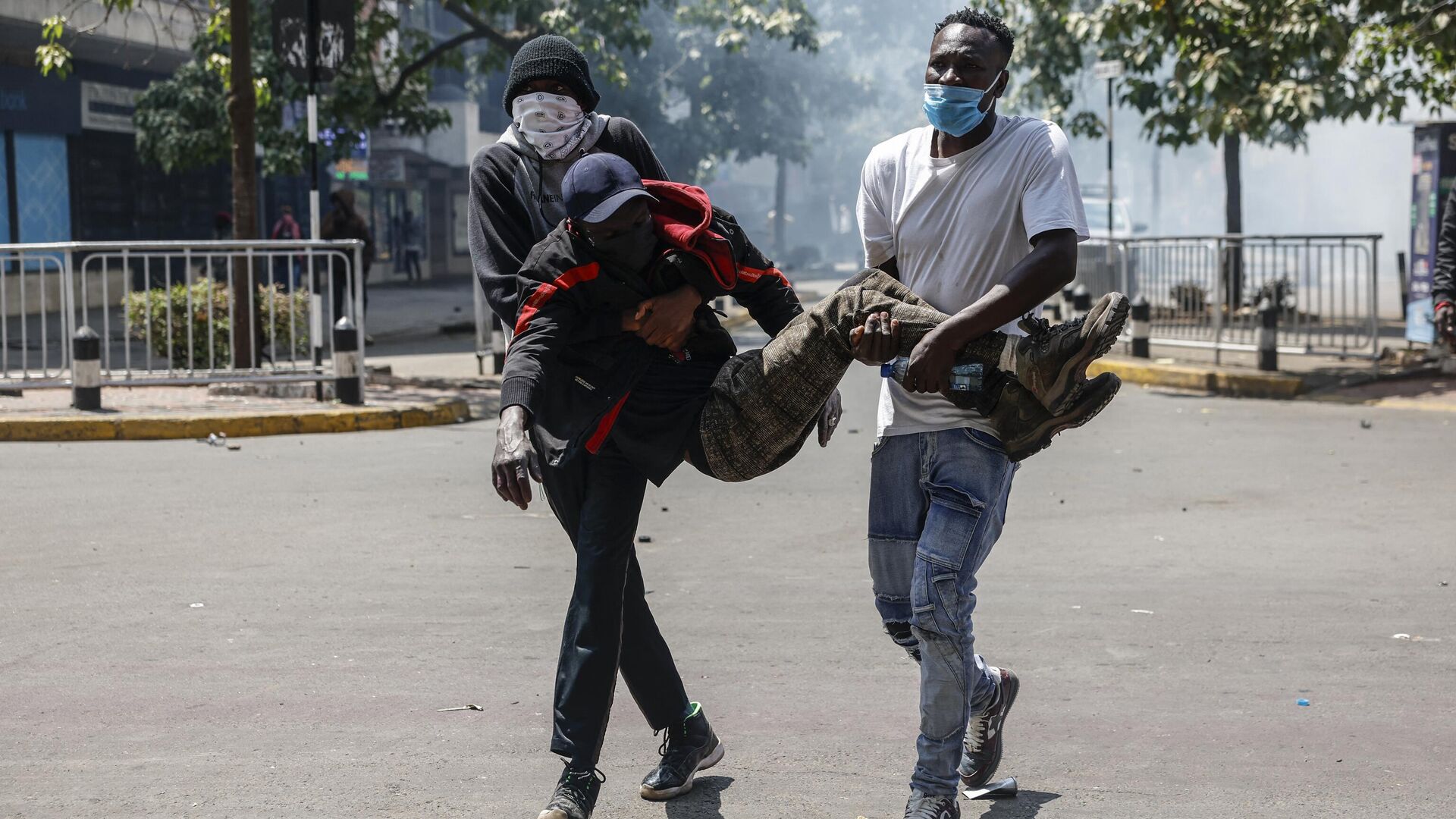 Раненого протестующего уносят с центра беспорядков в Найроби - РИА Новости, 1920, 25.06.2024
