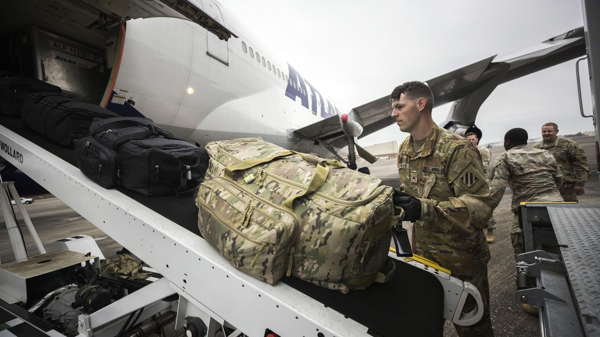 Американский военнослужащий загружает в грузовой отсек сумки - РИА Новости, 1920, 26.06.2024