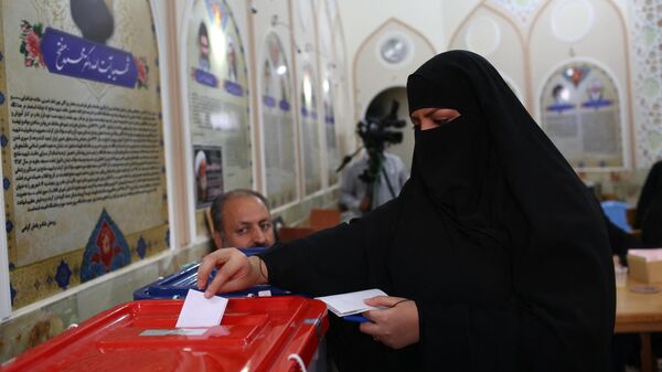 Женщина голосует на президентских выборах в священном городе Кум, Иран