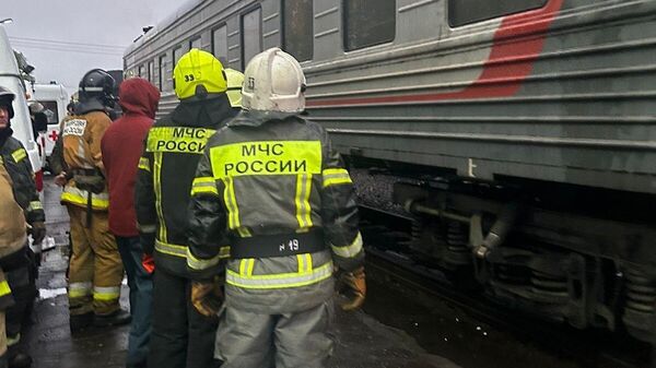 Сотрудники МЧС эвакуируют пострадавших из пассажирского поезда, сошедшего с рельсов в районе города Инта республики Коми