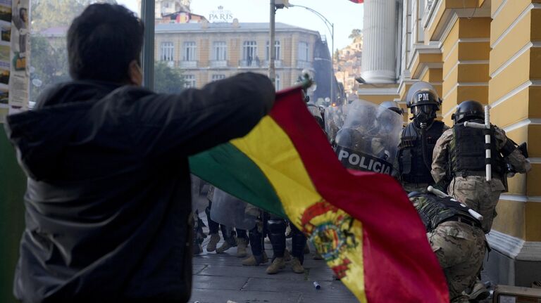 Сторонник президента Луиса Арсе после попытки государственного переворота на площади Мурильо в Ла-Пасе, Боливия