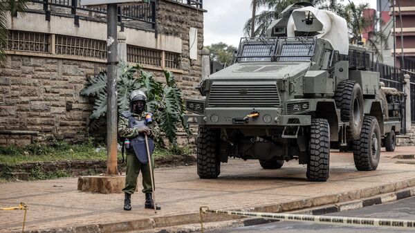Сотрудник кенийской полиции и бронемашина на улице Найроби
