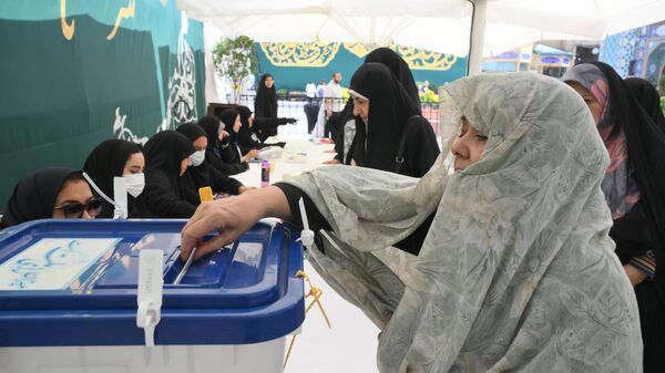 Женщина голосует на внеочередных выборах президента Ирана в Тегеране