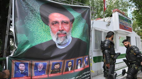 Портрет погибшего 8-ого президента Ирана Ибрахима Раиси у избирательного участка в Тегеране