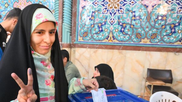 Женщина голосует на внеочередных выборах президента Ирана в Тегеране