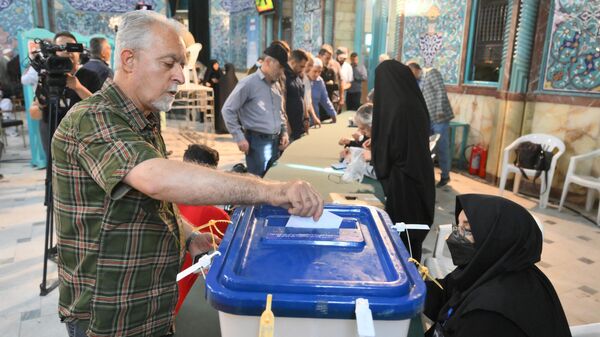 Мужчина голосует на внеочередных выборах президента Ирана в Тегеране