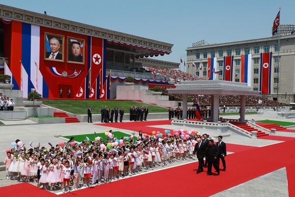 Президент РФ Владимир Путин и председатель государственных дел Корейской Народно-Демократической Республики Ким Чен Ын (справа на первом плане) во время церемонии официальной встречи на площади Ким Ир Сена в Пхеньяне