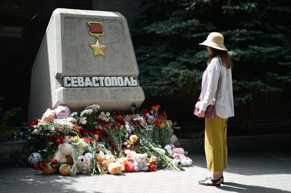 Женщина возле стихийного мемориала  у стелы Севастополя на Аллее городов-героев в день траура по погибшим в результате ракетной атаки Вооруженных сил Украины