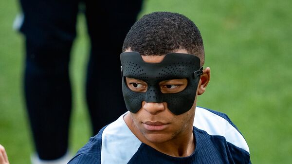 Нападающий сборной Франции по футболу Килиан Мбаппе в новой защитной маске после травмы носа