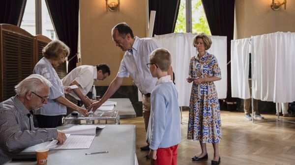 Избиратель голосует на избирательном участке во время первого тура выборов в Национальное собрание в Париже