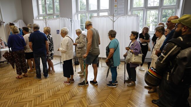 Избиратели стоят в очереди на избирательном участке во время первого тура выборов в Национальное собрание Франции