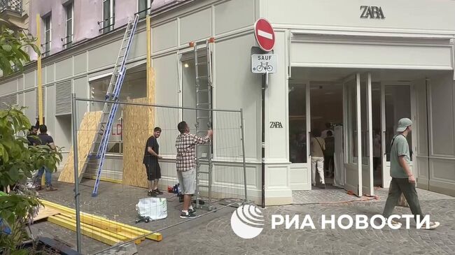 Магазины Парижа устанавливают фанерные щиты на витринах и дверях в ожидании беспорядков