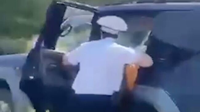 Сотрудник ДПС на ходу запрыгивает в машину, чтобы остановить неадекватного водителя на пляже в Красноярском крае. Кадр видео