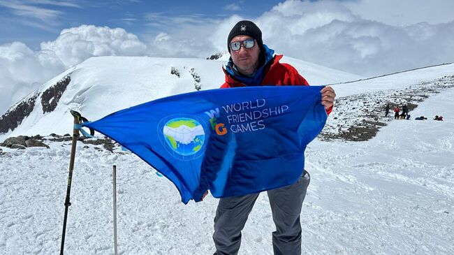 Алексей Сорокин с флагом Игр Дружбы на вершине Эльбруса