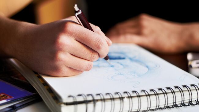 Девушка рисует в скетчбуке