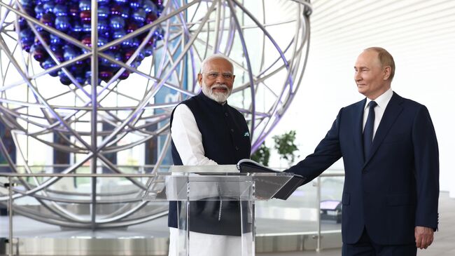 Президент РФ Владимир Путин и премьер-министр Индии Нарендра Моди во время посещения павильона Атом на ВДНХ