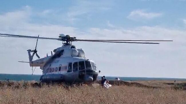Вертолет Симферопольского звена Южного авиационно-спасательного центра МЧС России вылетает для спасения человека на сапборде. Кадр видео