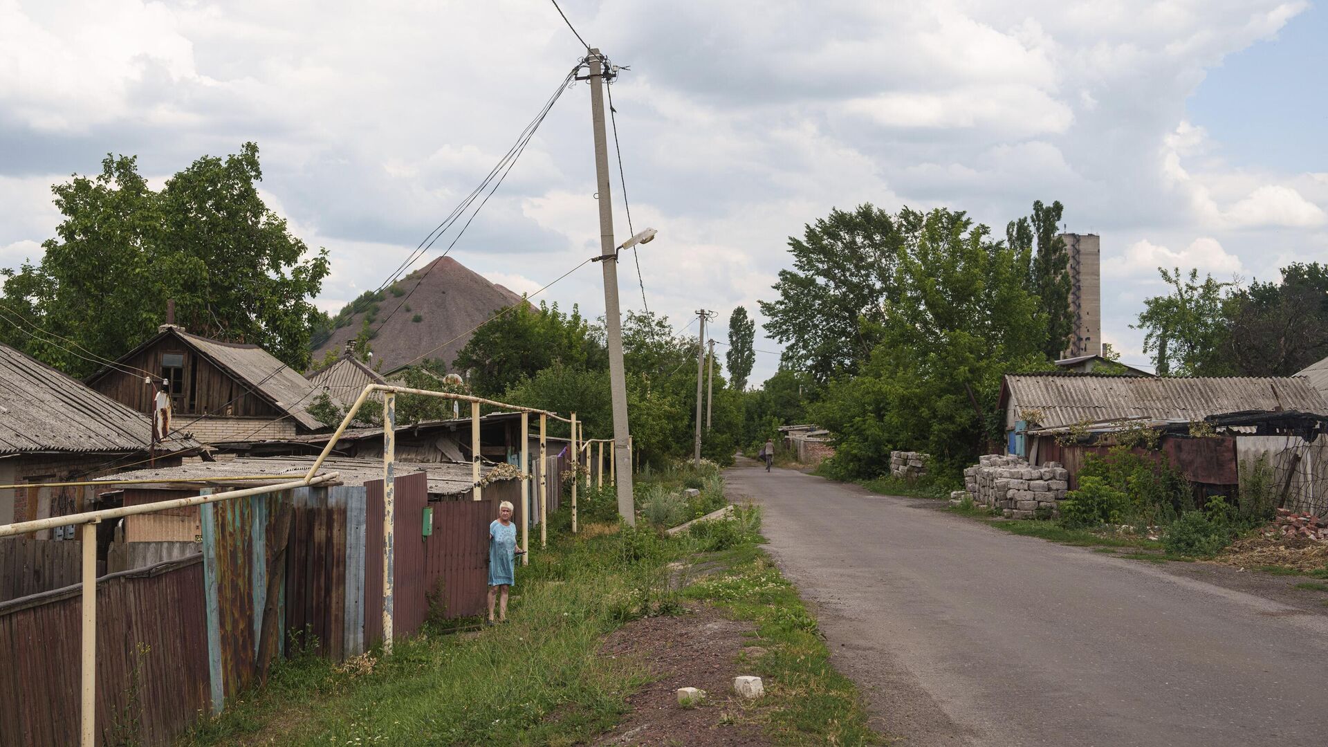 Женщина смотрит на улицу из своего дома во время эвакуации в городе Дзержинск (Торецк) - РИА Новости, 1920, 01.08.2024