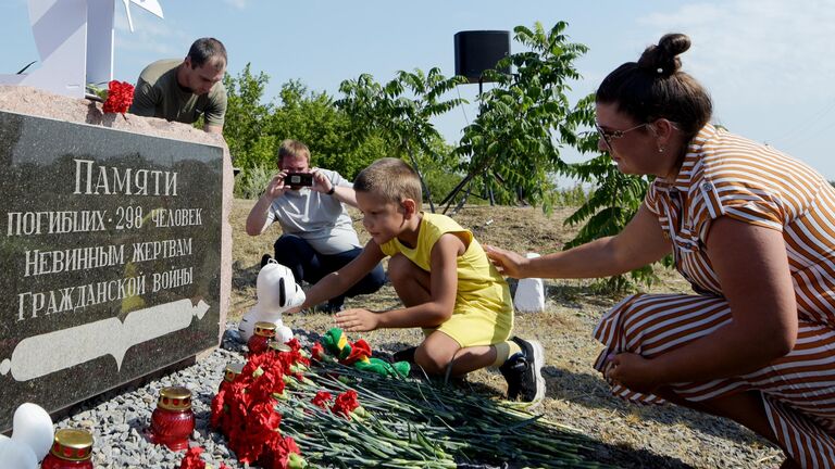 Люди возлагают цветы к мемориалу на памятных мероприятиях на месте крушения пассажирского лайнера Boeing-777 (MH17) в селе Грабово Донецкой Народной Республики