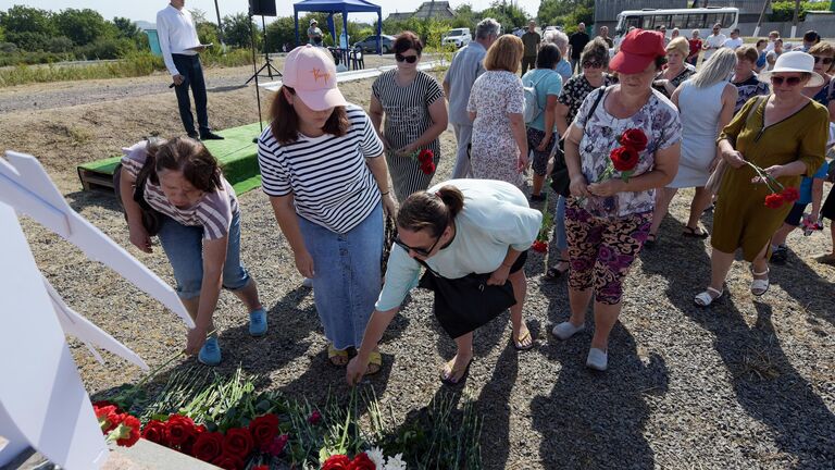 Люди возлагают цветы к мемориалу на памятных мероприятиях на месте крушения пассажирского лайнера Boeing-777 (MH17) в селе Грабово Донецкой Народной Республики