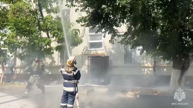 Сотрудники МЧС во время ликвидации пожара на крыше четырехэтажного дома в Волгограде. Кадр видео