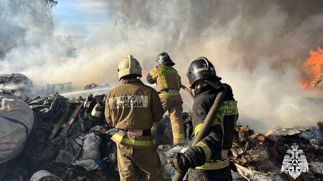 Сотрудники МЧС во время ликвидации пожара в Рязани, где горит прессованная бумага