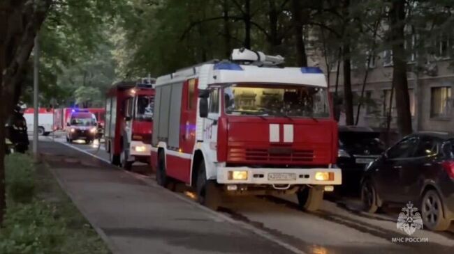Автомобили МЧС на улице Молодежная в Москве во время тушения пожара в жилом доме