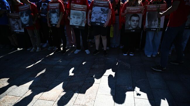 Участники акции в память о погибших детях Донбасса с портретами детей, погибших из-за обстрелов Донбасса вооруженными силами Украины, у посольства США в Москве