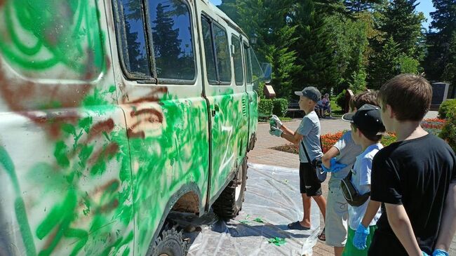 Дети красят буханку в защитный цвет