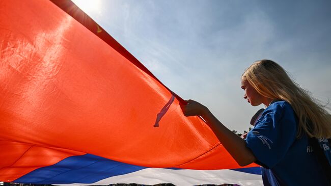 Девушка держит флаг России