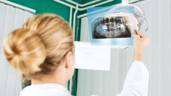 Стоматолог смотрит снимок полости рта