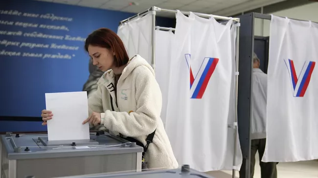 Девушка голосует на избирательном участке