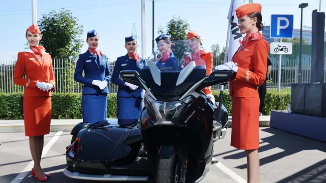 Стюардессы группы Аэрофлот у электрического мотоцикла Aurus Merlon, который участвует в мотопробеге по маршруту Москва - Суздаль - Москва, посвящённом Году семьи