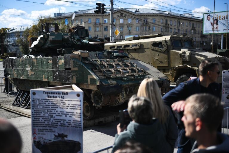 Посетители осматривают выставку Сила V правде - гордость и победа на площади Пименова в Новосибирске