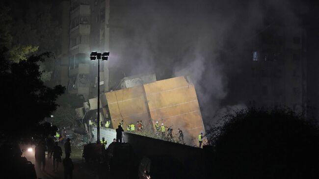 Спасатели на месте израильского авиаудара в южном пригороде Бейрута, Ливан