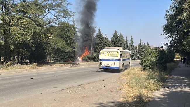 Автобус проезжает мимо горящего автомобиля