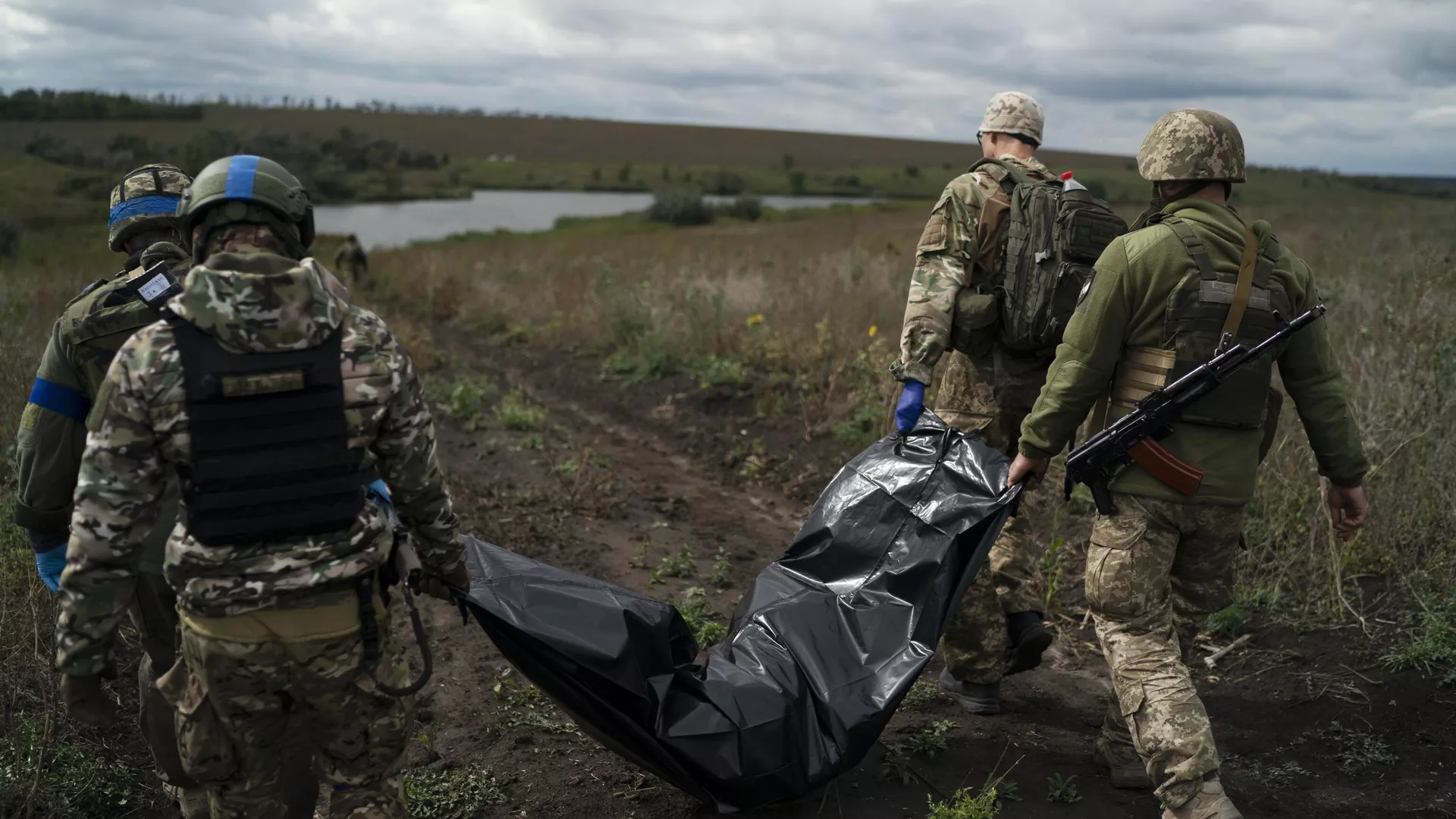 Украинские военнослужащие несут тело погибшего украинского военного в Харьковской области - РИА Новости, 1920, 17.10.2024