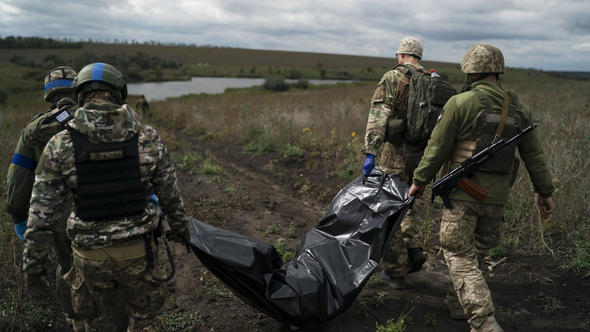 Украинские военнослужащие несут тело погибшего украинского военного - РИА Новости, 1920, 20.10.2024